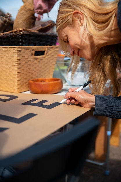 Foto zijaanzichtvrouw bij garage sale