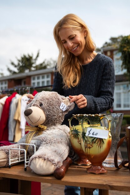 Foto zijaanzichtvrouw bij garage sale