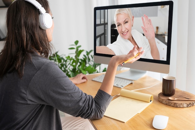 Foto zijaanzichtvrouw die een videogesprek voert