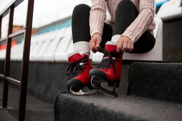 Foto zijaanzichtvrouw die schaatsen aantrekt