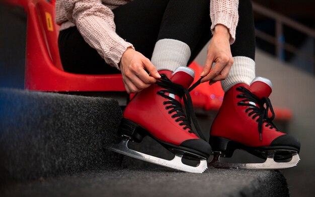 Foto zijaanzichtvrouw die schaatsen aantrekt