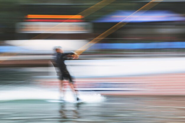 Zijdebeeld van de wazige beweging van een wakeboarder