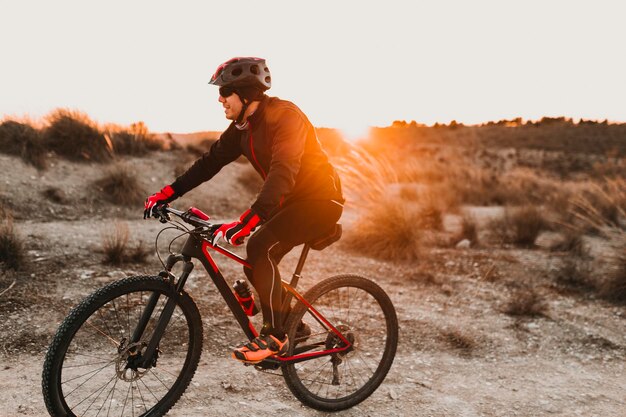 Foto zijdebeeld van een man die op de weg fietsen