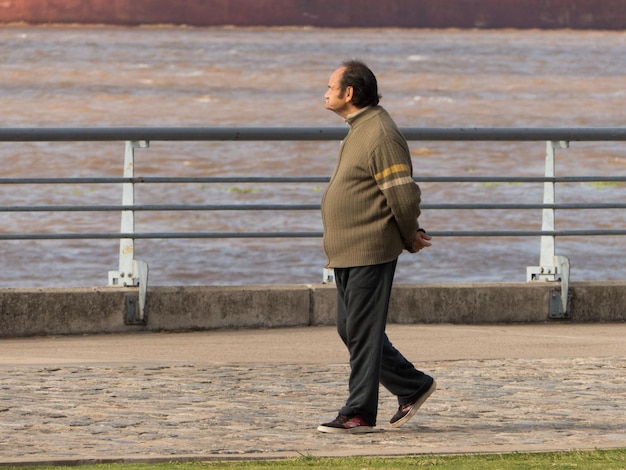 Foto zijdebeeld van een man die tegen een reling staat