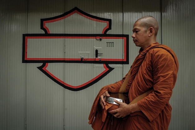 Foto zijdebeeld van een monnik die tegen de muur staat