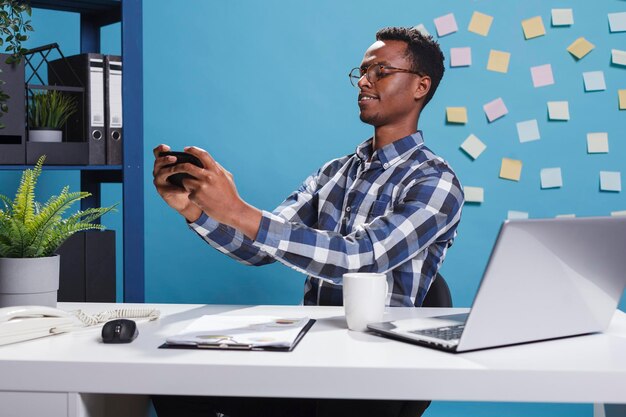 Zijkant van een jonge man die een laptop gebruikt op kantoor