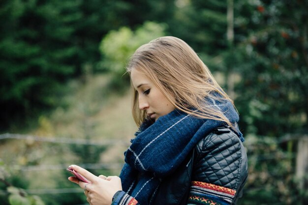 Foto zijkant van een jonge vrouw die buiten staat