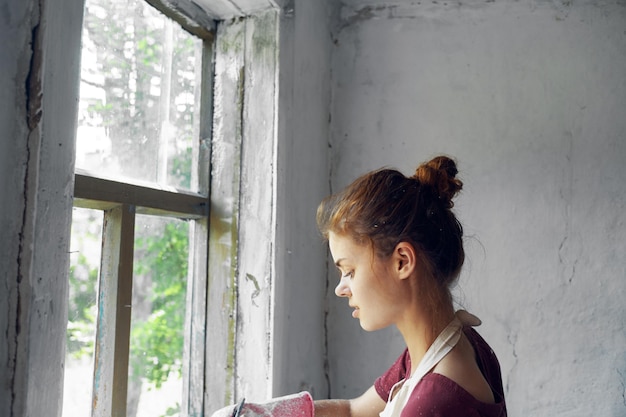 Foto zijkant van een jonge vrouw die door het raam kijkt