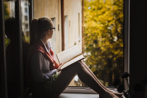 Foto zijkant van een jonge vrouw die een boek leest