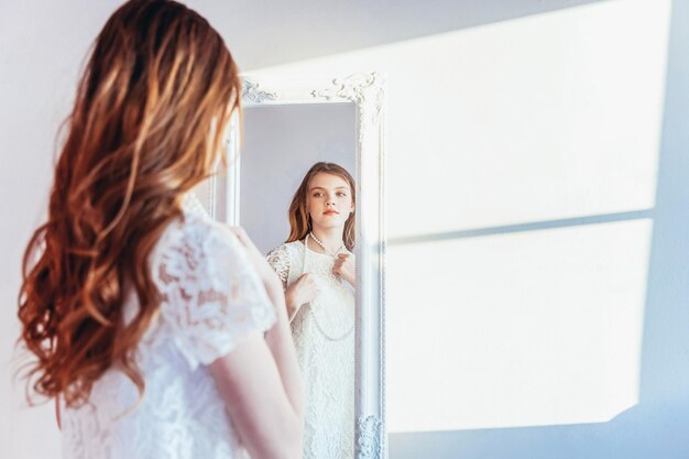 Foto zijkant van een jonge vrouw die tegen de muur staat