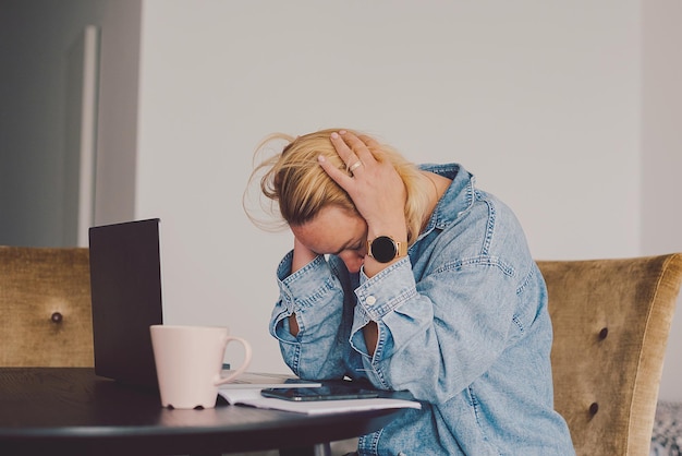 Zijkant van een jonge vrouw die thuis een mobiele telefoon gebruikt