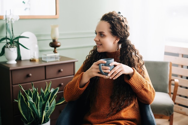 Zijkant van een jonge vrouw die thuis een mobiele telefoon gebruikt