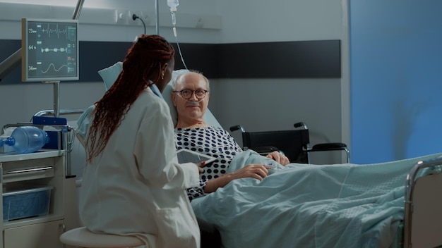 Foto zijkant van een jonge vrouw die thuis op het bed zit