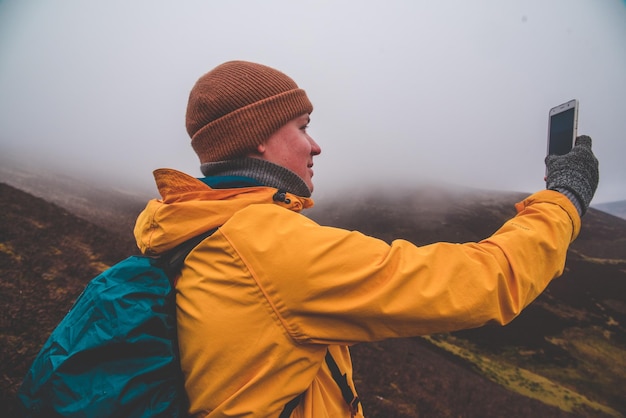 Zijkant van een man die een selfie maakt op de berg