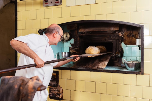 Foto zijkant van een man die in een werkplaats werkt