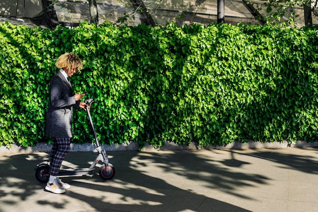 Zijkant van een man die op een elektrische scooter tegen bomen rijdt