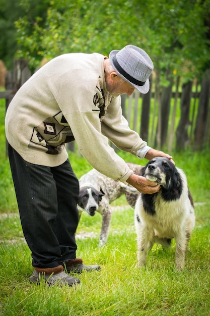 Zijkant van een oudere man met honden op een grasveld