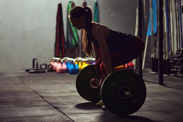 Foto zijkant van een vrouw die in de sportschool traint