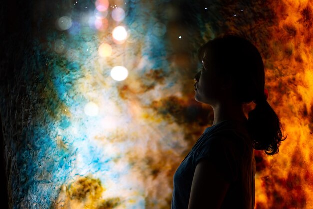 Foto zijkant van een vrouw die's nachts naar verlichte lichten kijkt