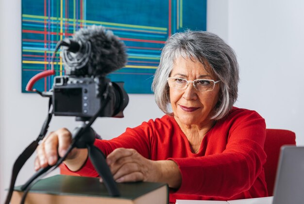 Foto zijkantbeeld van een jonge vrouw die thuis zit met haar mobiele telefoon