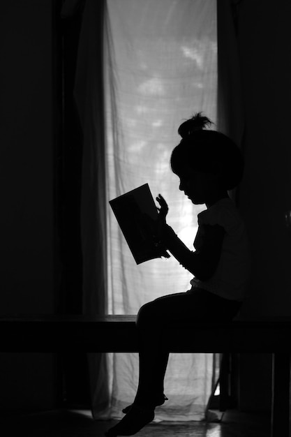 Zijkantbeeld van een silhouet jongen die thuis staat