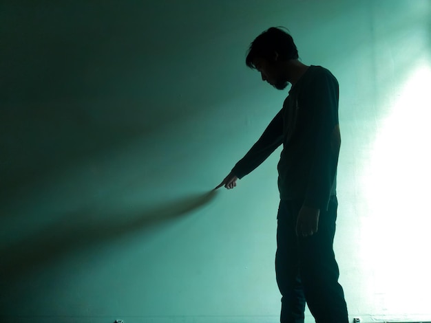 Zijkantbeeld van een silhouet man die tegen een verlichte scène staat