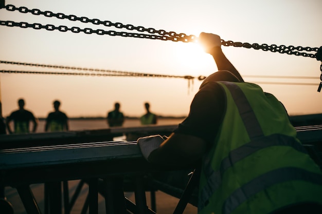 Foto zijkantbeeld van een silhouet man die tijdens de zonsondergang bij een reling tegen de hemel staat