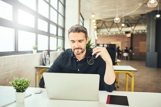 Zijn werk spreekt voor zich Bijgesneden opname van een volwassen zakenman die op zijn laptop op kantoor werkt