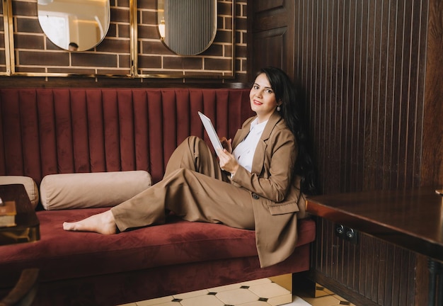 Zijprofielfoto van een zakenvrouw die aan de telefoon praat zakenvrouw zittend op een bank in een gezellig café