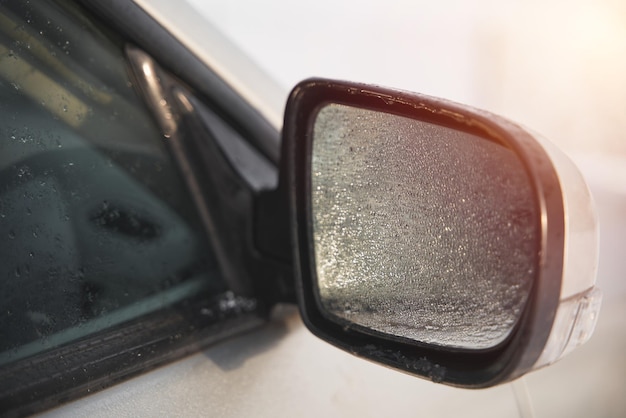 Zijspiegel bedekt met regendruppels Elektrisch aangedreven autospiegel