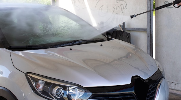 Zilveren auto wassen van vuil bij een selfservice carwash