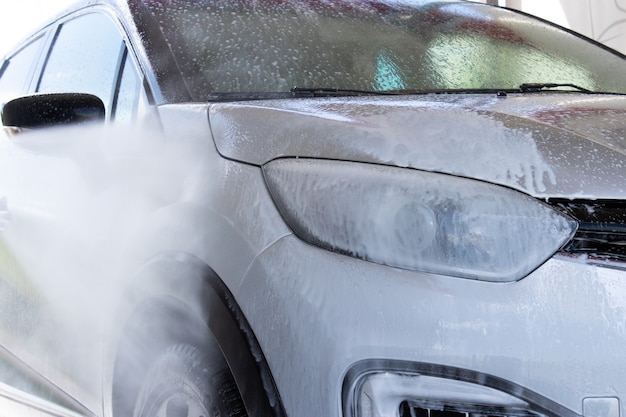 Zilveren auto wassen van vuil bij een selfservice carwash