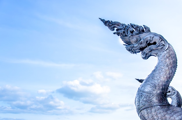 Zilveren Naga-standbeeld in Thaise tempel op blauwe hemelachtergrond