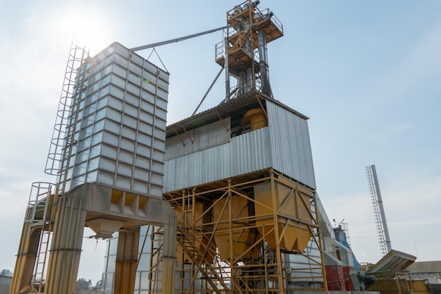 Zilveren silo's op agro-fabriek voor verwerking drogen reiniging en opslag van landbouwproducten meel granen en graan Grote ijzeren vaten graan Graanschuurlift