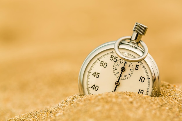 Zilveren stopwatch in het zand op het strand