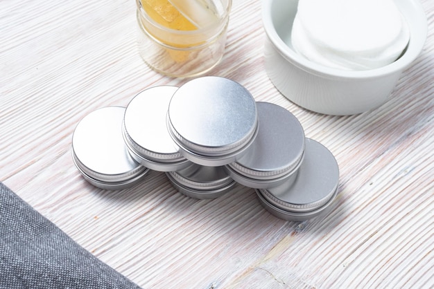 Zilverkleurige tinnen metalen dozen voor glanzende crème make-up cosmetica op houten tafel