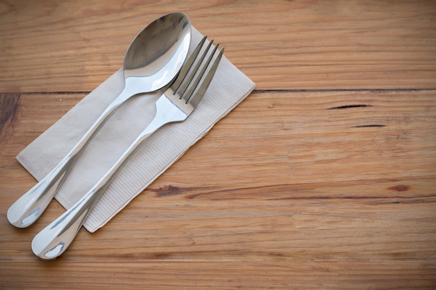 Zilverwerk, vork lepel en papier op houten eettafel set in de linkerhand gericht voor kopie ruimte op rechterhand afbeelding voor make-up concept achtergrond