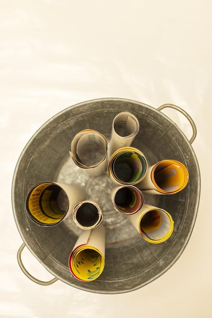 A zinc bucket with rolled up posters