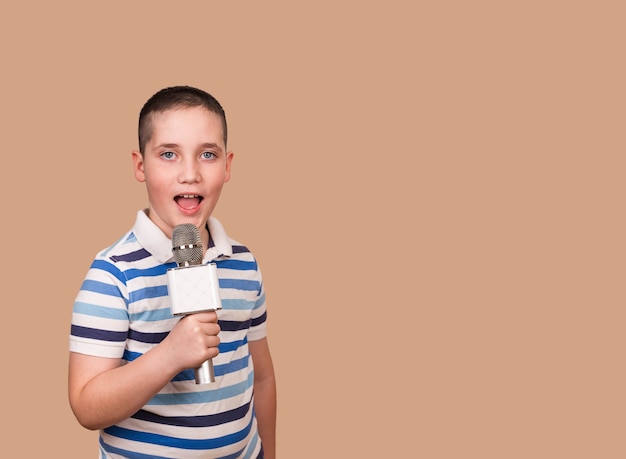 Zingend kind houdt microfoon in zijn handen. De jongen neemt zijn lied op