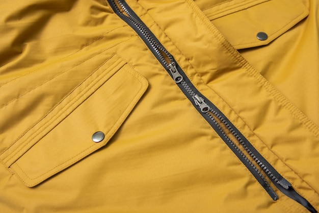 Фото Молния и накладные карманы на водостойкой желтой куртке для весны и осени.