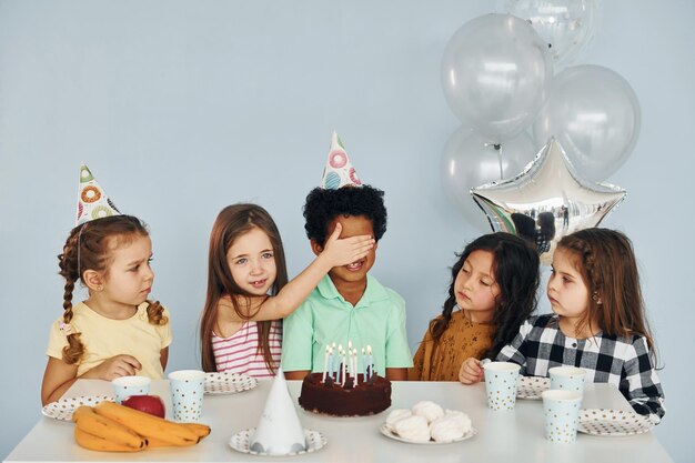 Zit bij de tafel Kinderen op verjaardagsfeestje binnenshuis hebben plezier samen