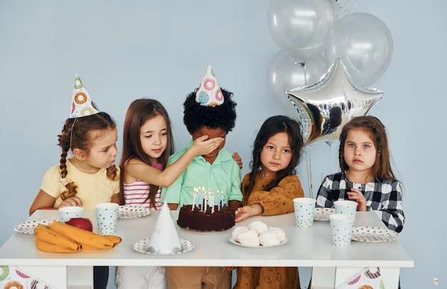 Zit bij de tafel Kinderen op verjaardagsfeestje binnenshuis hebben plezier samen