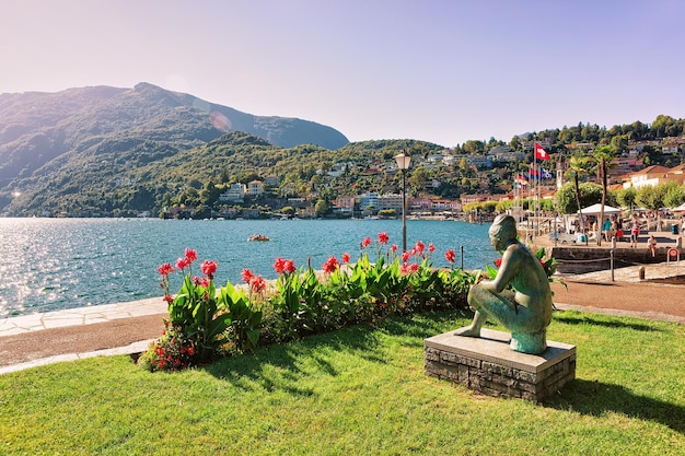 Zittende vrouw sculptuur aan de promenade van het luxe resort in Ascona aan het Lago Maggiore in het kanton Ticino, Zwitserland. Mensen op de achtergrond.