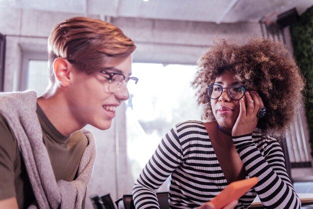 Zo interessant. Opgetogen jongen die een glimlach op zijn gezicht houdt terwijl hij naar zijn gadget staart