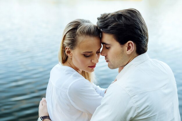 Zo romantisch. Leuk opgetogen stel dat samen bij de rivier zit terwijl ze genieten van hun romantische date