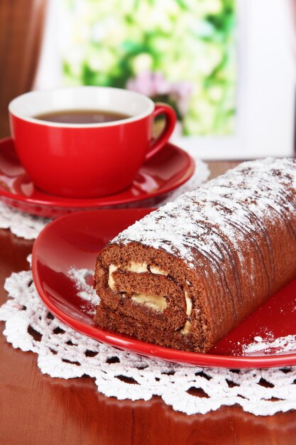 Zoet broodje met kopje thee op tafel in de kamer