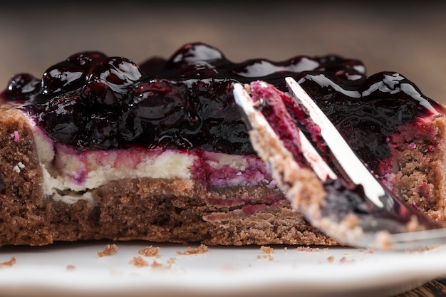 Zoet dessert gemaakt van zuivelproducten en bessen, cake met botercrème en zwarte bessenjam