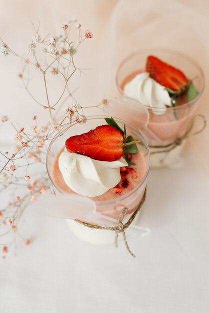 Zoet dessert in een glas versierd met verse rode aardbeien en room