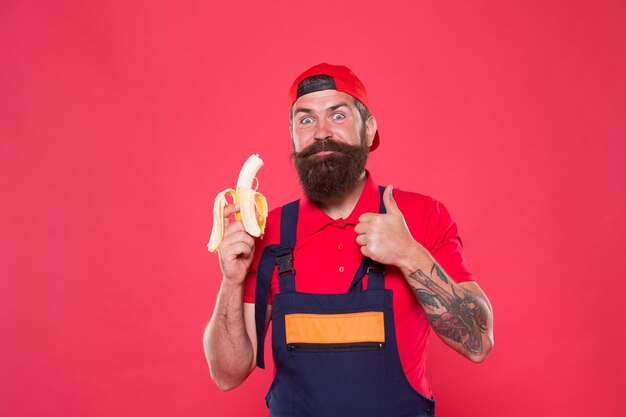 Zoet en zacht Hongerige hipster eet favoriete eten vrolijke werknemer die banaan vers biologisch fruit eet, gezond eten en op dieet zijn Goede gezondheidszorg voedingsconcept smakelijke verleiding Gezond leven leven