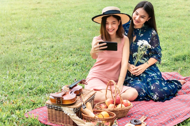 Zoet moment van liefde. Portret van Aziatische homoseksuele paar grappige selfie en picknick in het park. Concept LGBT leasbian.